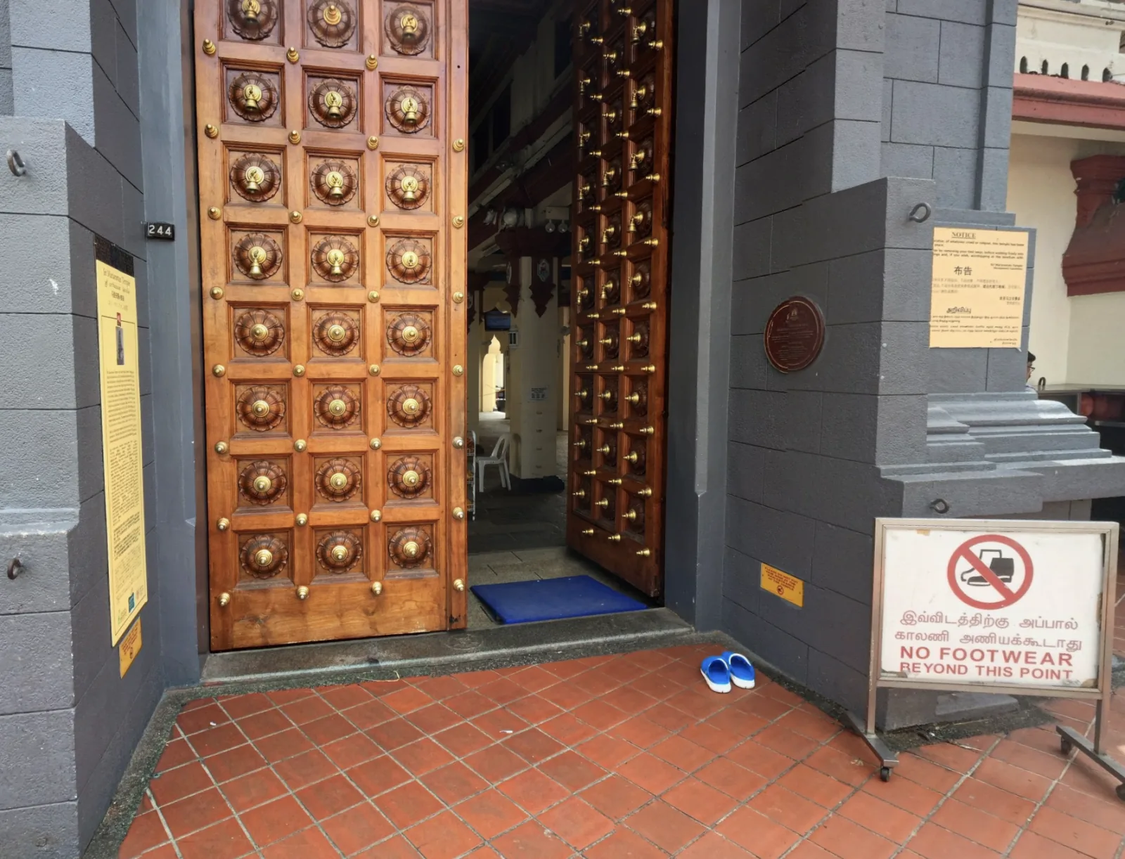 Temple doorway with a sign reading No footwear beyond this point in Tamil and English